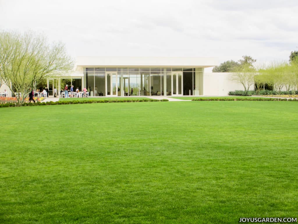 a mid-century modern building at sunnylands center & gardens with a bright green lawn in the foreground