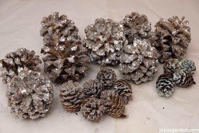 a grouping of many small to medium sized sparkly, crystal glitter pine cones that have been lightened & glittered