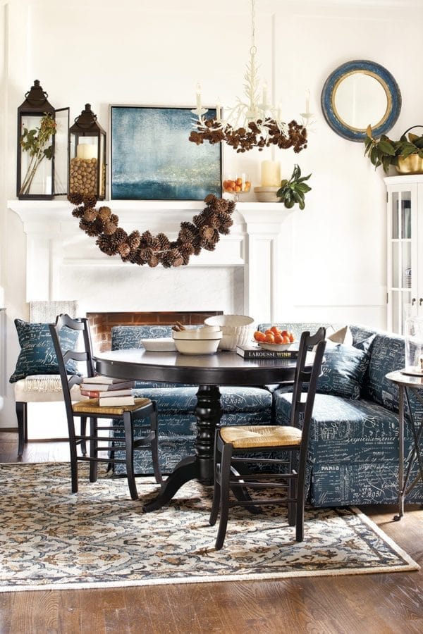 a dining knook with a fireplace is decorated with pine cone craft DIYs for the holidays