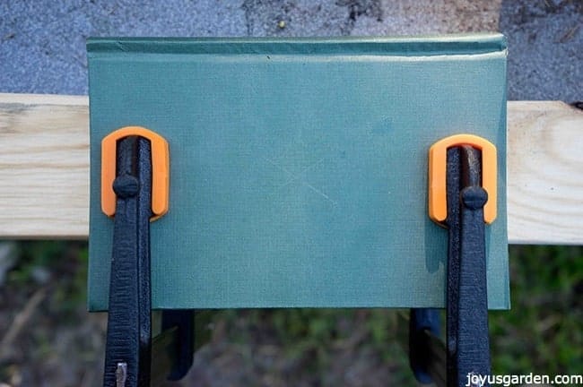 green vintage book clamped into a board