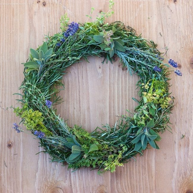 a wreath made of herbs accented with lavender flowers