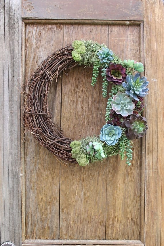 an artificial succulent wreath on a grapevine form