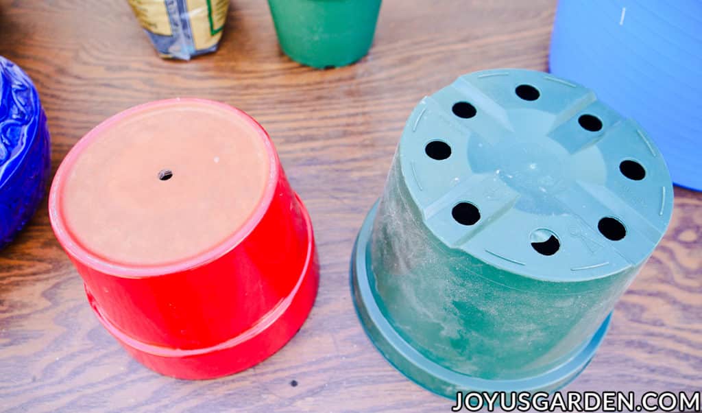 a red ceramic & a green grow pot are turned upside down on a work table