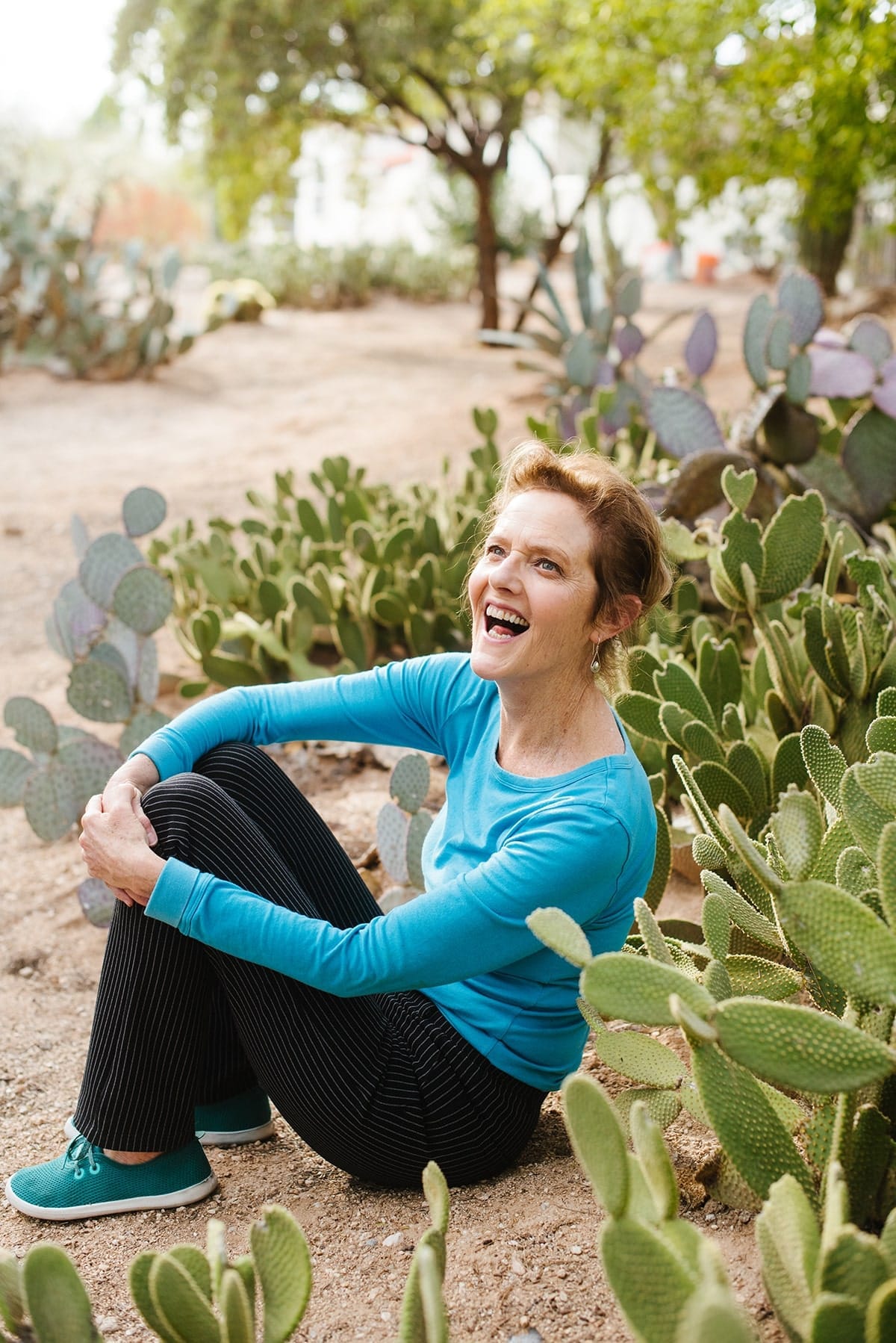 Nell sitting in front of several cactus plants in the Arizona desert