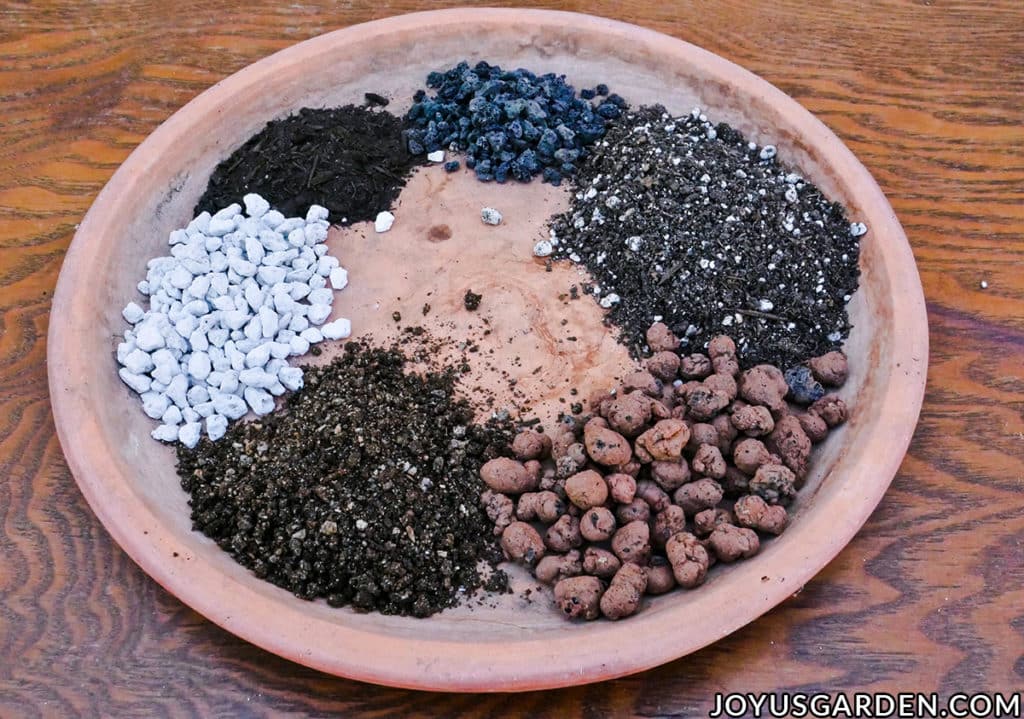the ingredients for a dracaena plant soil mix displayed on a terra cotta saucer