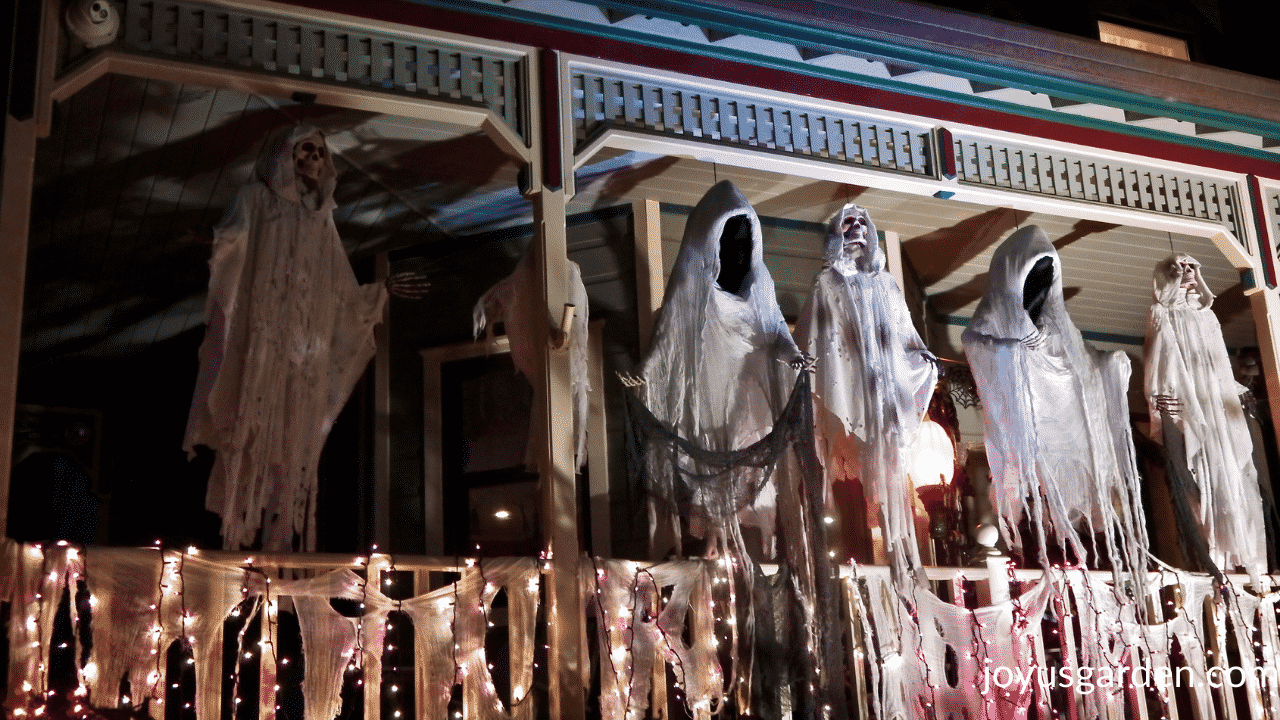 5 large ghouls are displayed on a front porch for halloween