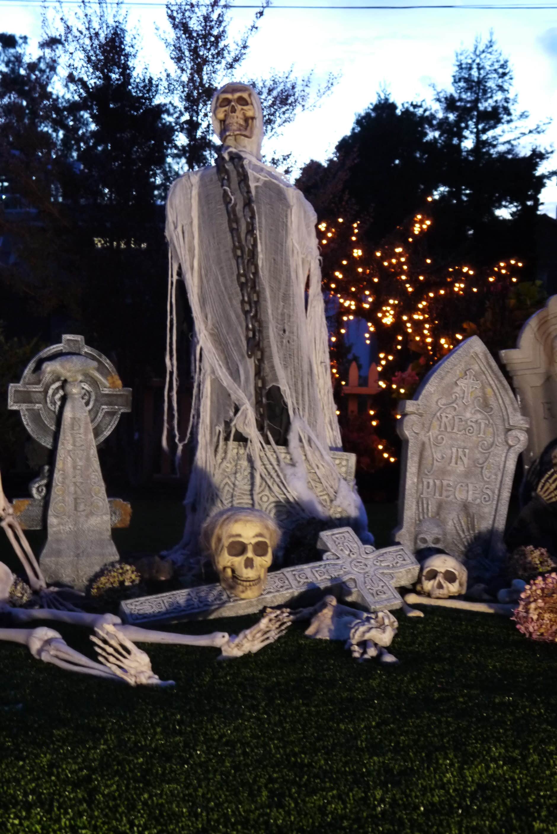a larger ghoul stands over a halloween cemetery scene at night