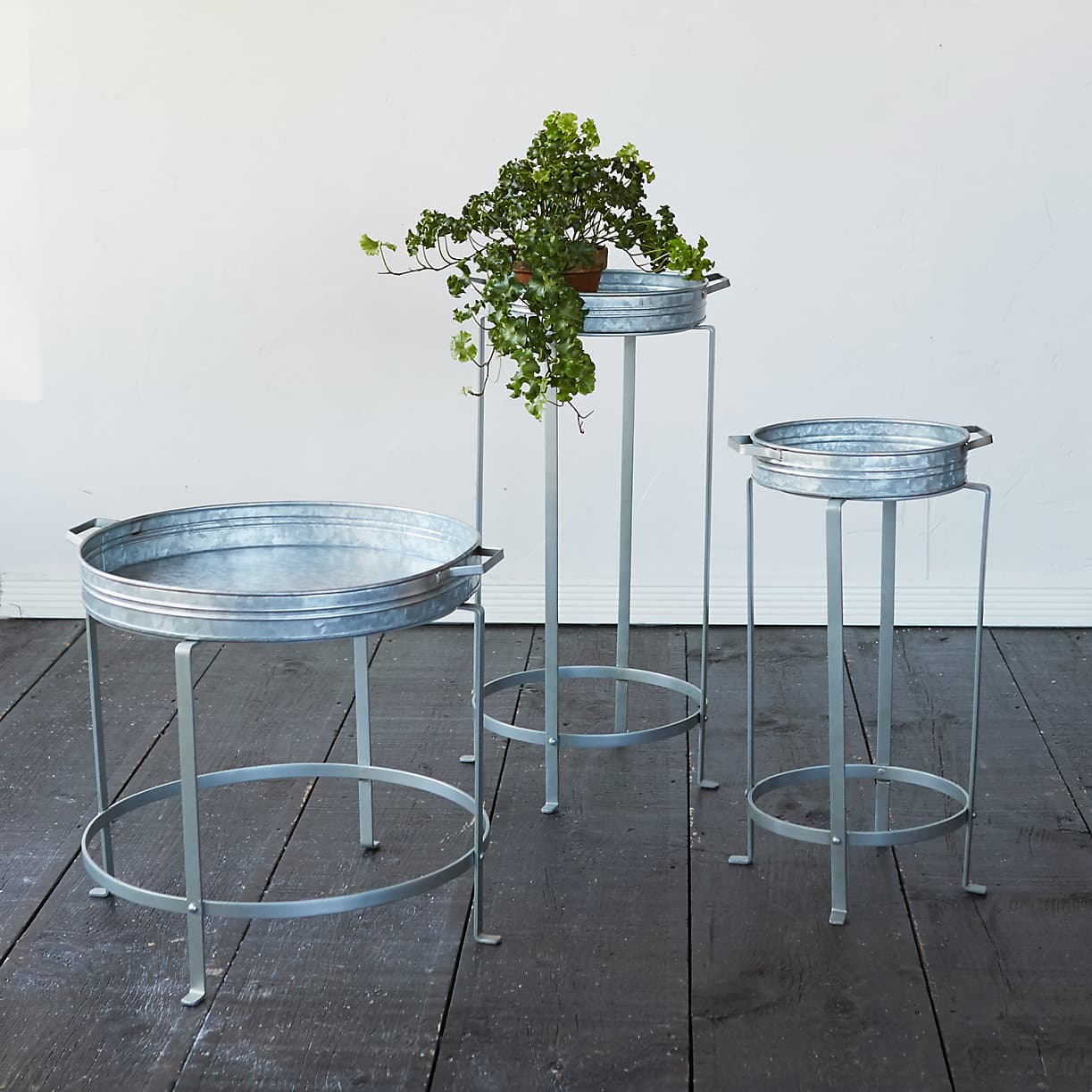 Three plant stands made of metal in varying heights. 