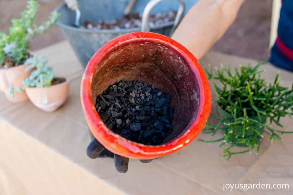 close up of the inside of a decorative pot with 2 layers of drainage materials