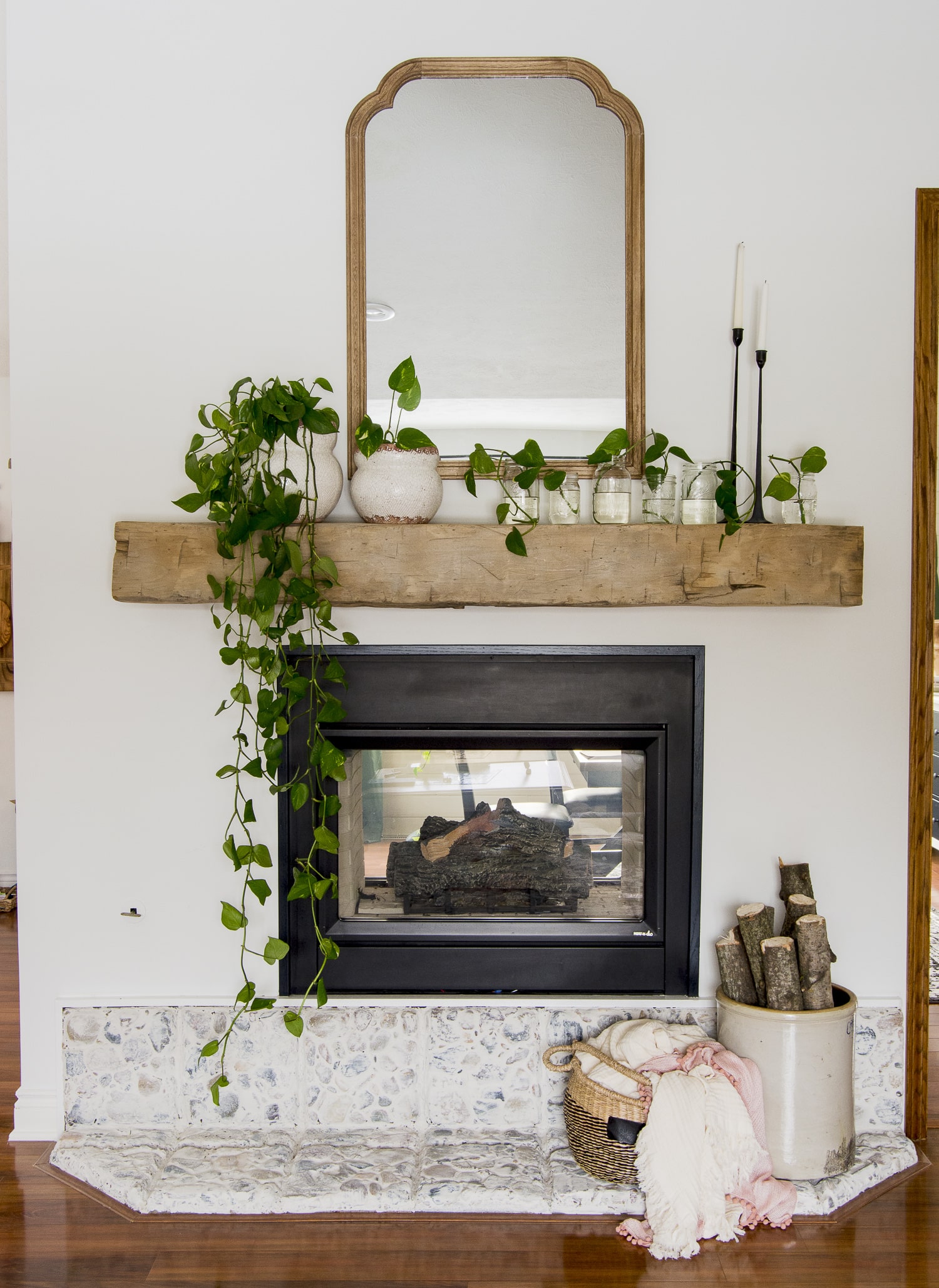 a white fireplace decorated with trailing pothos