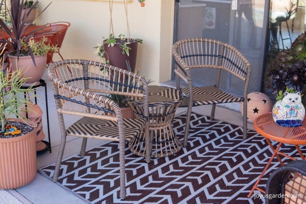 a black & tan seating seat on a patio with plants