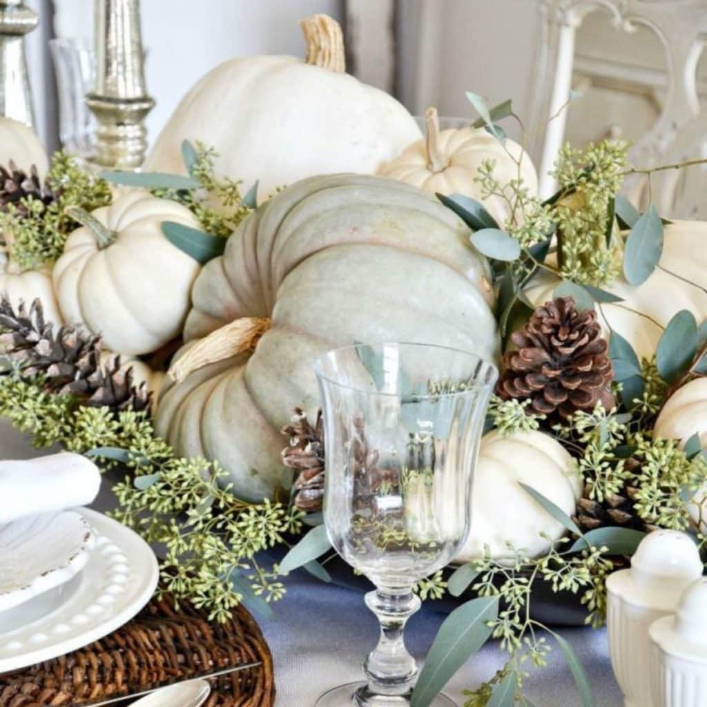 a beautiful fall tablescape with green & white pumpkins, seeded eucalyptus & pinecones