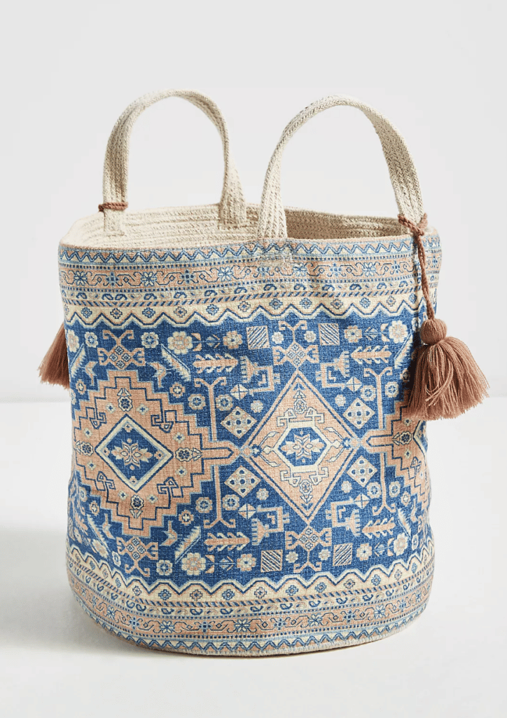 a bohemian style kabi printed basket with a pattern on it, handles, & tassels to buy at anthropologie