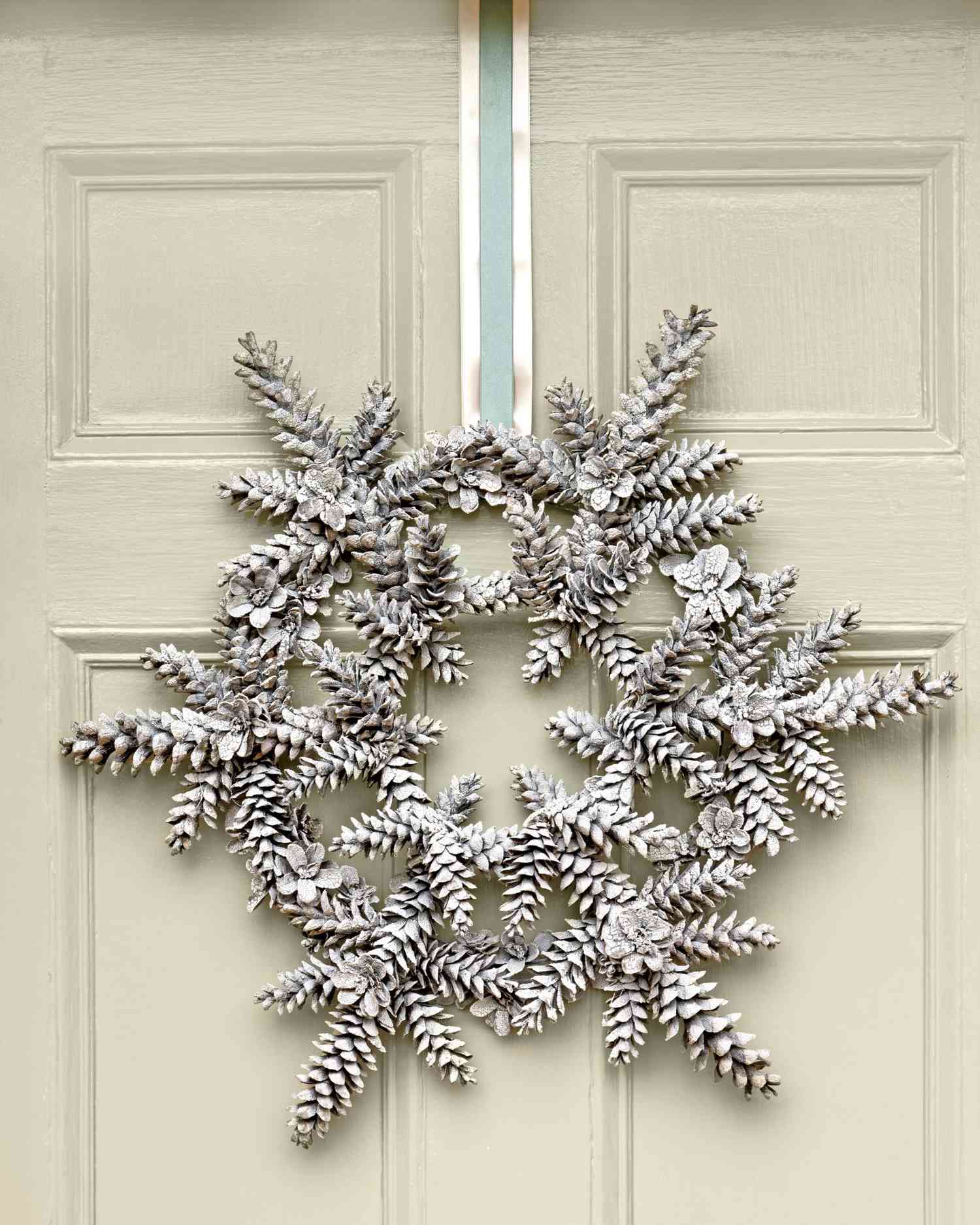snowflake-shaped pinecone wreath hung on a door