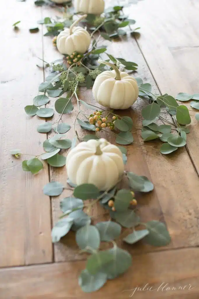 A simple fall centerpiece with white miniature pumpkins & eucalyptus.