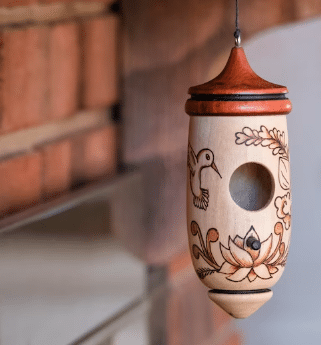 Wood carved hummingbird house with decorative design from Etsy.