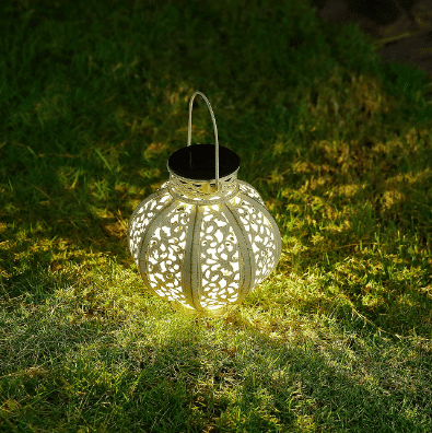 Solar light sits on grass yard illuminating the surrounding grass from amazon.