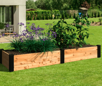 Wooden raised garden bed with flowers and plants growing inside from walmart.