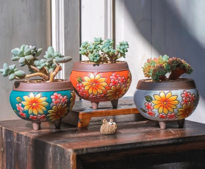 Floral clay succulent planters with succulents inside from Etsy.